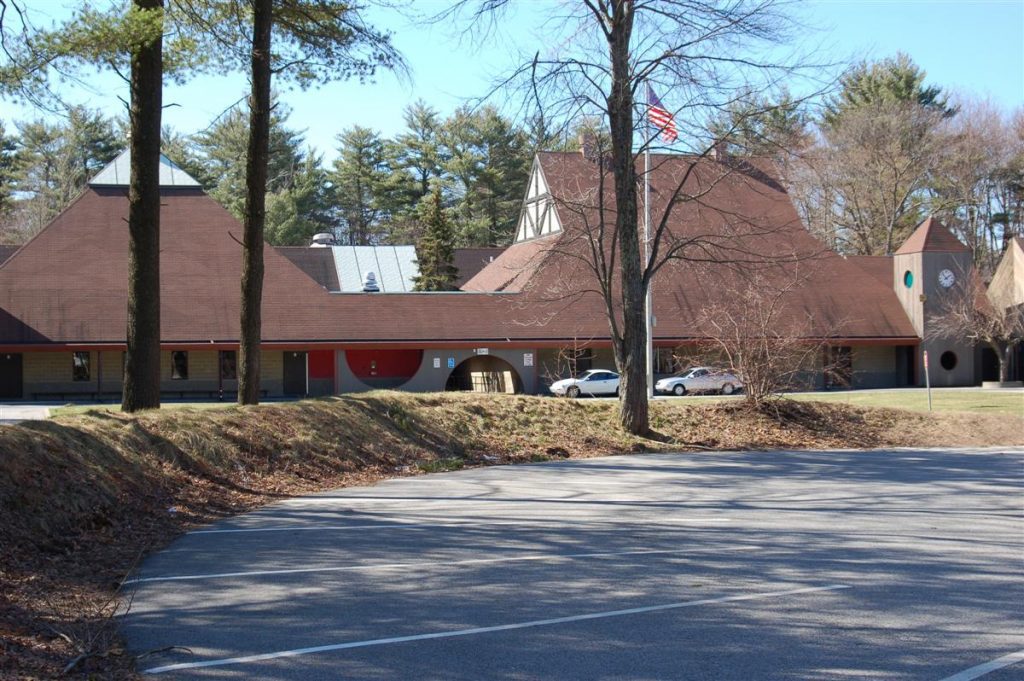 Photograph of Bancroft Elementary School with steeply-pitched roofs, Tudor-style decoration, and a clock tower.