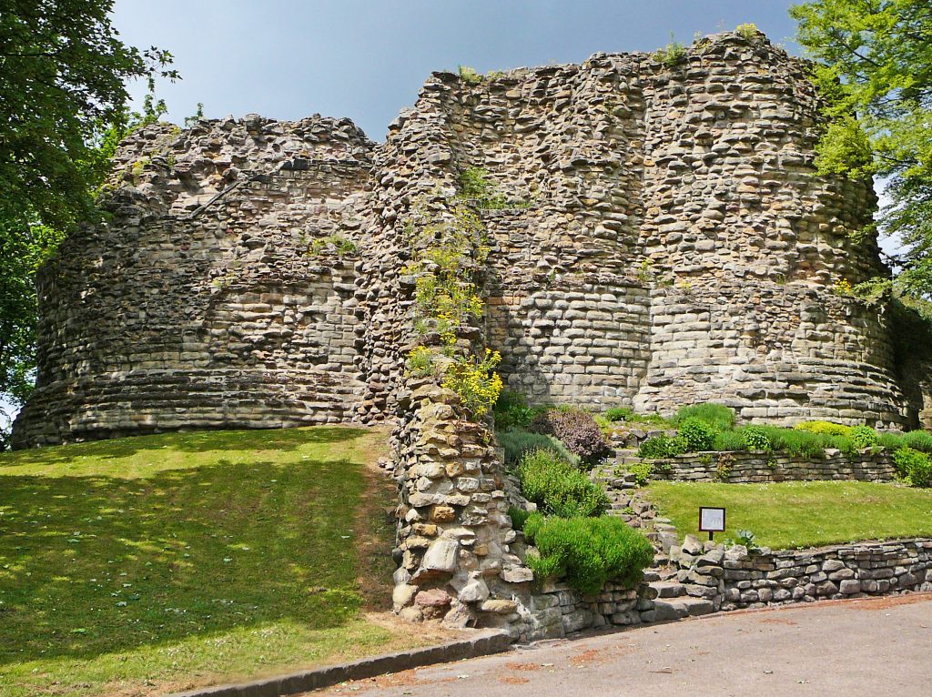 Photograph of the ruins of Pontefract Castle, with a solid base of blocks of gray stone.