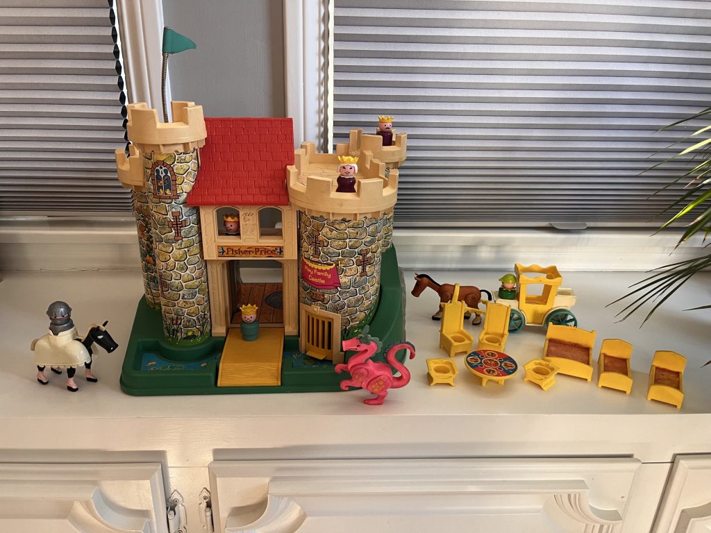 Fisher-Price play castle with figures, carriage, and dragon.