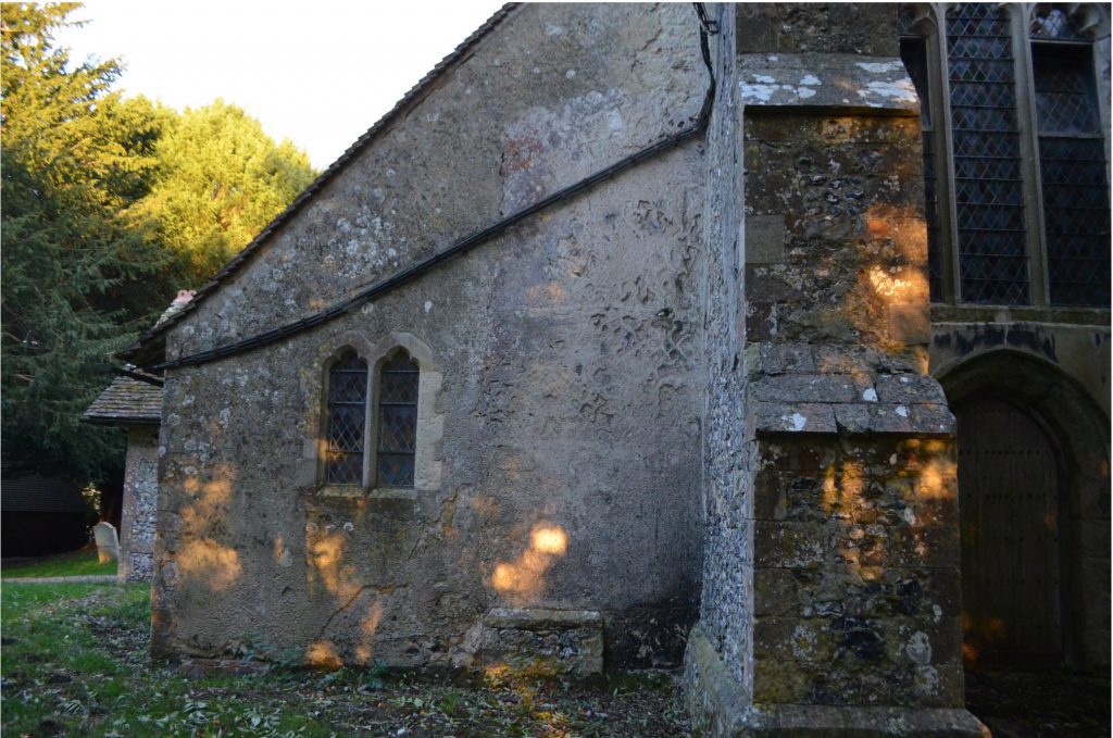 North aisle of stone church building from the exterior.