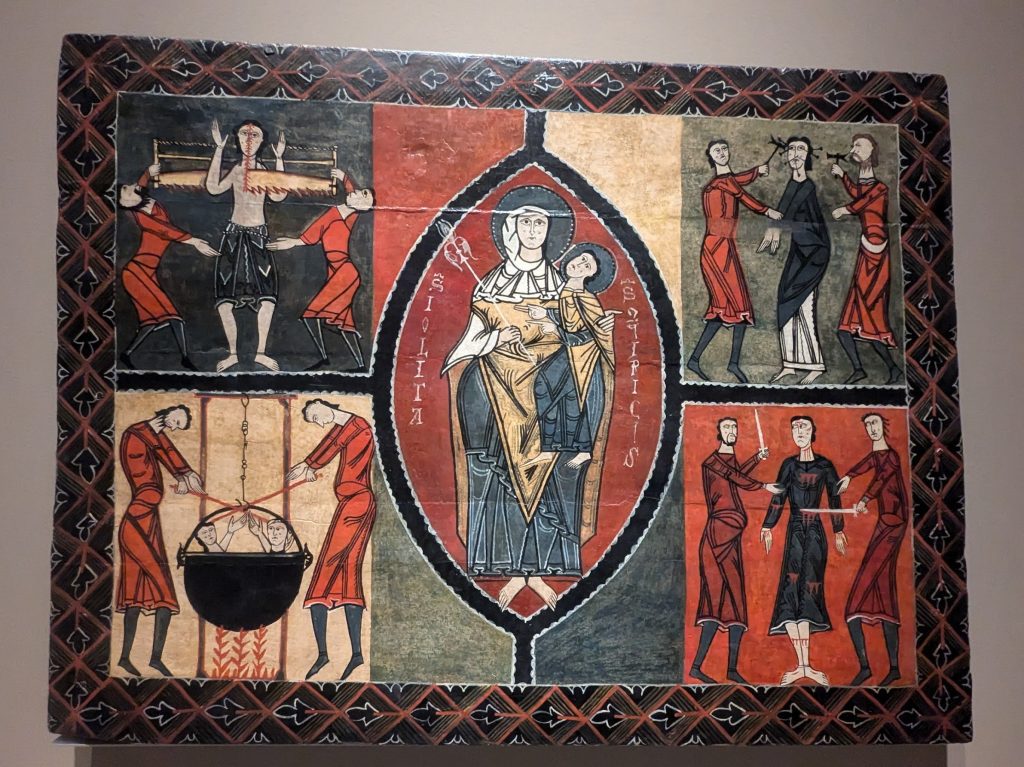 Wooden altar frontal panel. In the center, in a mandorla, is the Virgin with the Christ Child on her lap (throne of wisdom). Around this central scene are four compartments showing the tortures of St. Quircus. At the top left, the saint is being cut in half with a crosscut saw by two figures.