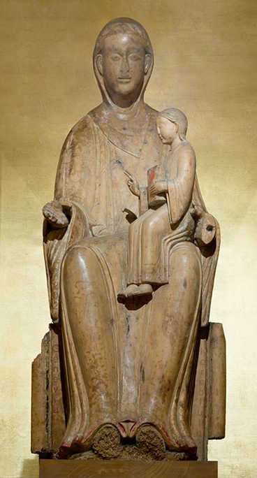 Wooden sculpture of a seated woman with a child in her lap.
