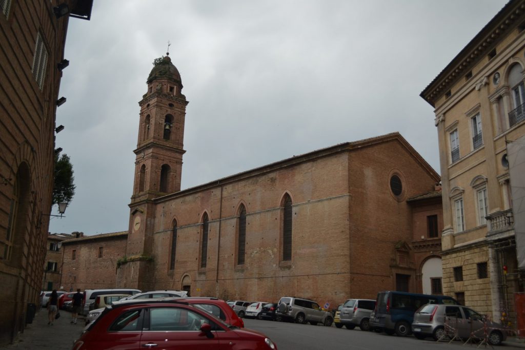 Brick church with long, narrow windows and a bell tower.