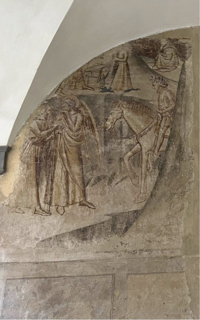 Monk and man approach a man on a horse.