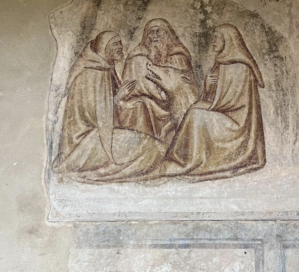 Three monks surround a pig.