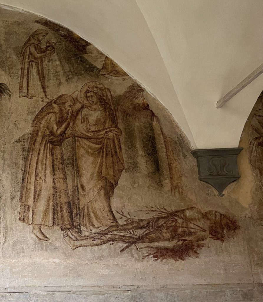 A monk and angel walk towards a corpse.