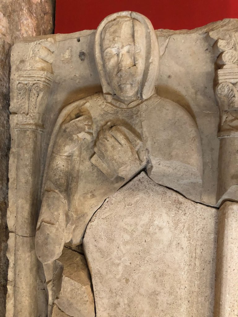 A stone relief sculpture of a man, viewed from the shoulders up.