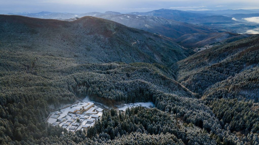 Sacred Hermitage of Camaldoli surrounded by silver fir trees in winter snow.