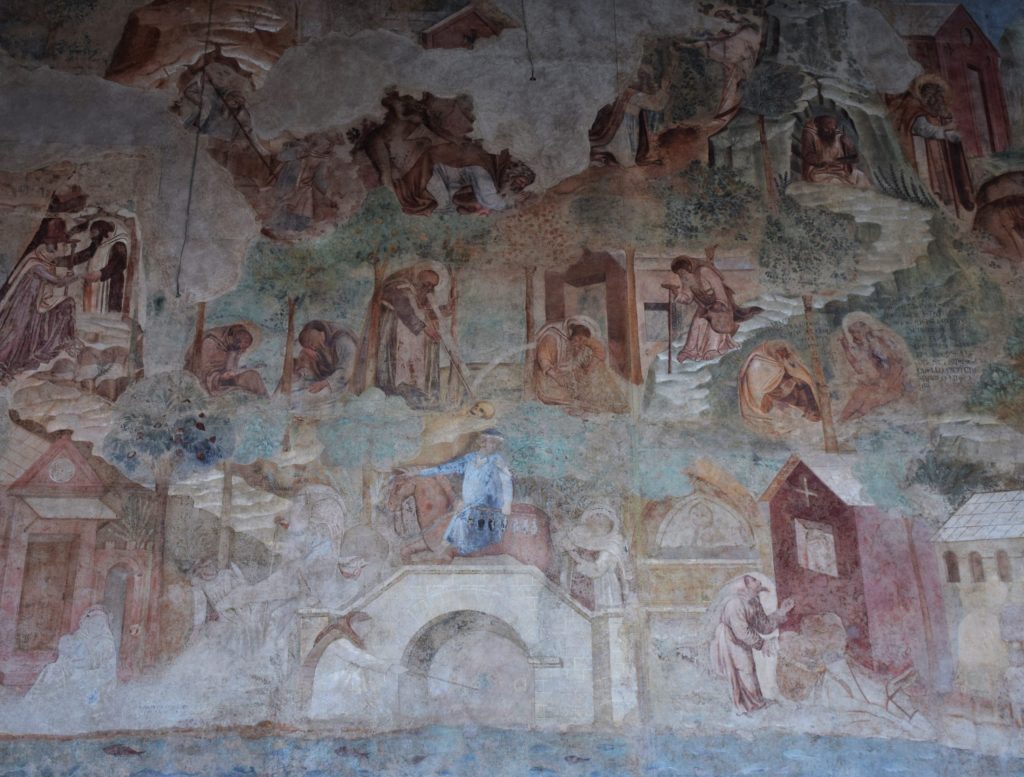 Part of a wall painting with figures of hermits in a landscape and two sequences of steps leading up from a river into the hills.