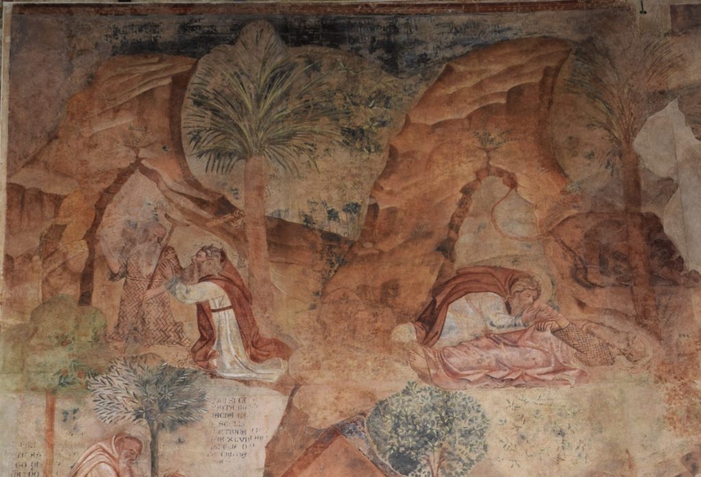 Part of a wall painting showing two hermits in a desert landscape. On the left, the hermits are meeting, and on the right, one has died and the other is going to bury him.