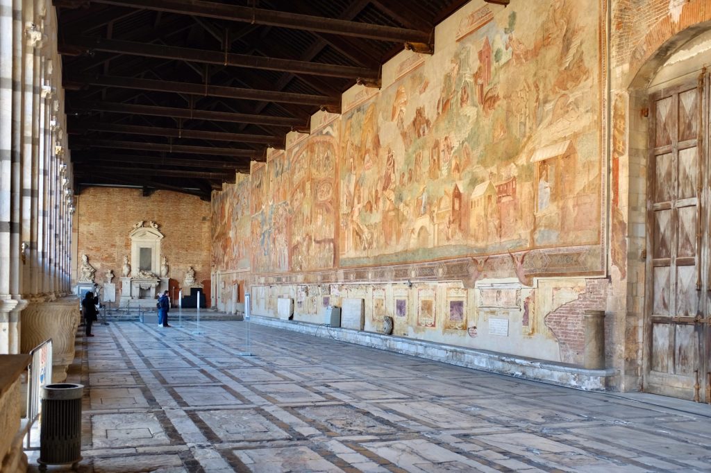 Interior view along the southern gallery of the Camposanto (looking eastwards), with frescoes by Buffalmacco on the right-hand wall.