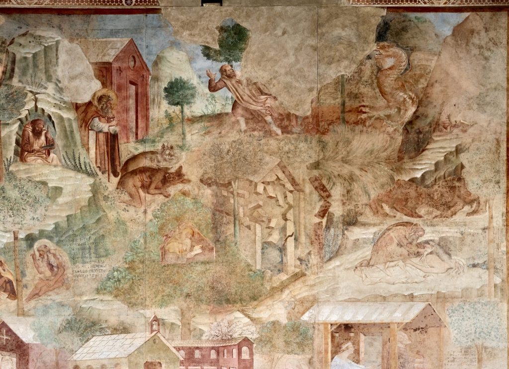 Detail of the Thebaid fresco, with scenes of the desert saints Anthony Abbot (expelling demons), Hilarion (whose figure is lost, fighting a dragon), and Onophrius and Paphnutius, with other hermits and lions in a mountainous landscape.