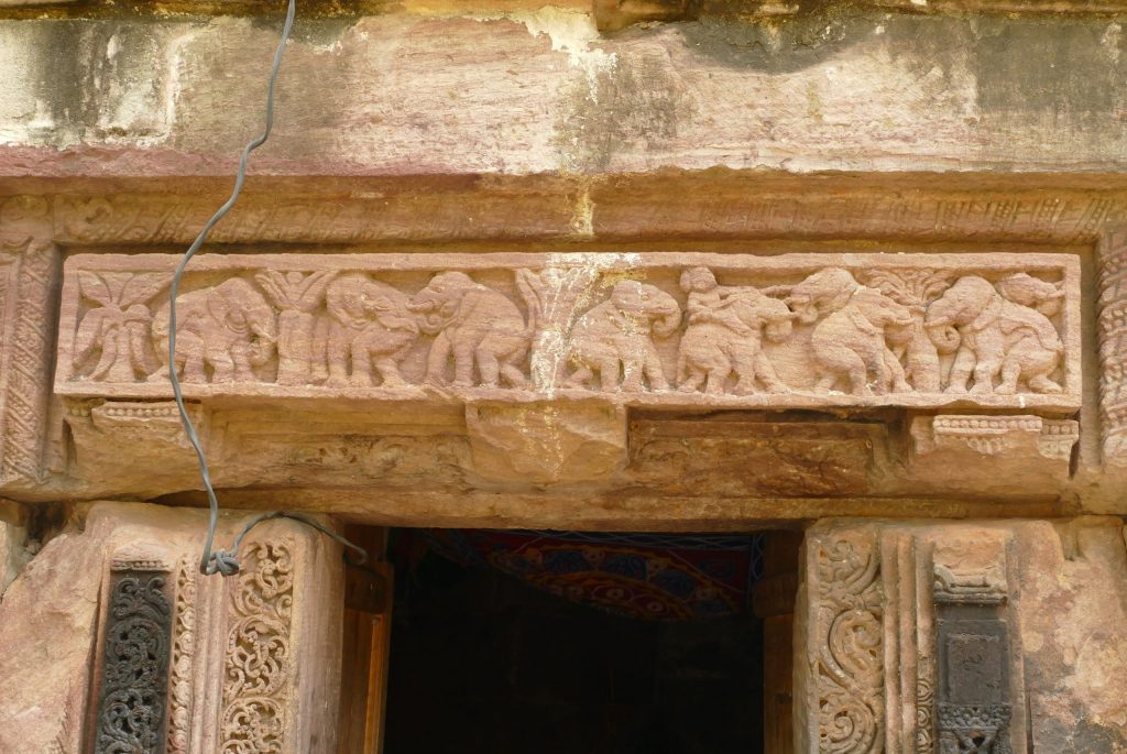 Stone relief on temple lintel. A herd of elephants, a human rides one elephant and holds an elephant goad. Satrughnesvara, Bhubaneswar, Odisha.