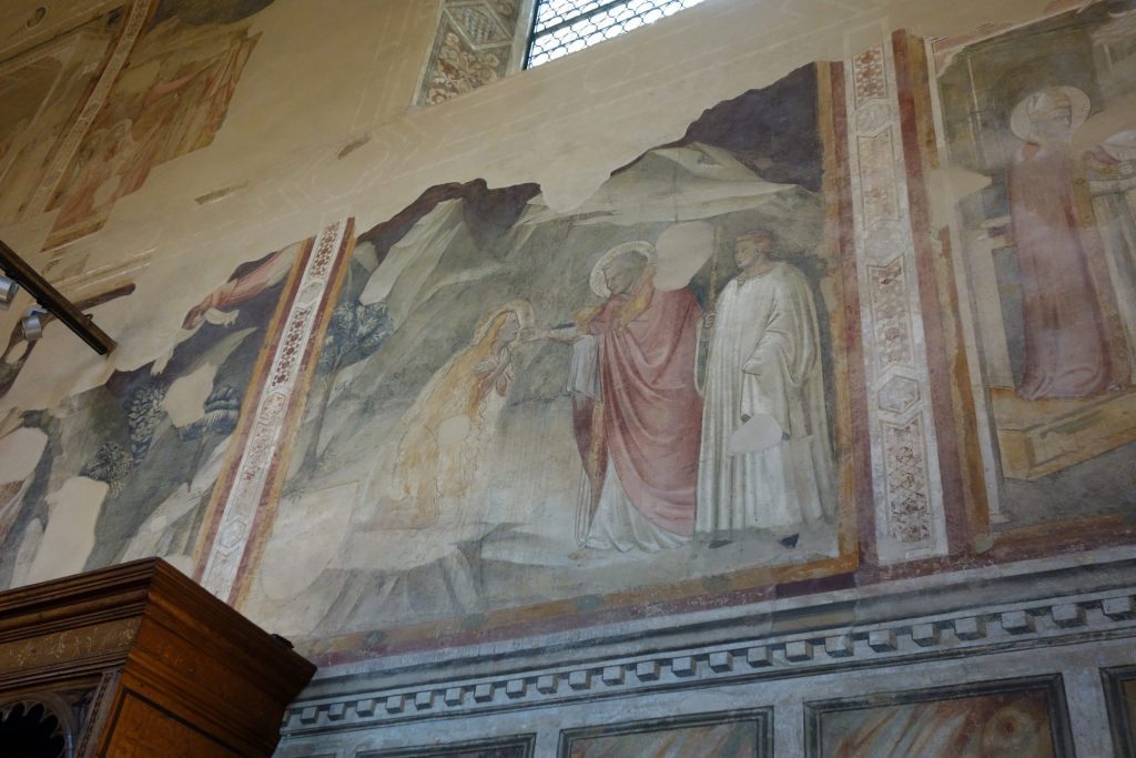 A very damaged fresco, depicting the naked Magdalen kneeling in the wilderness, receiving Last Communion from St. Maximin, who is here accompanied by an acolyte dressed in white.