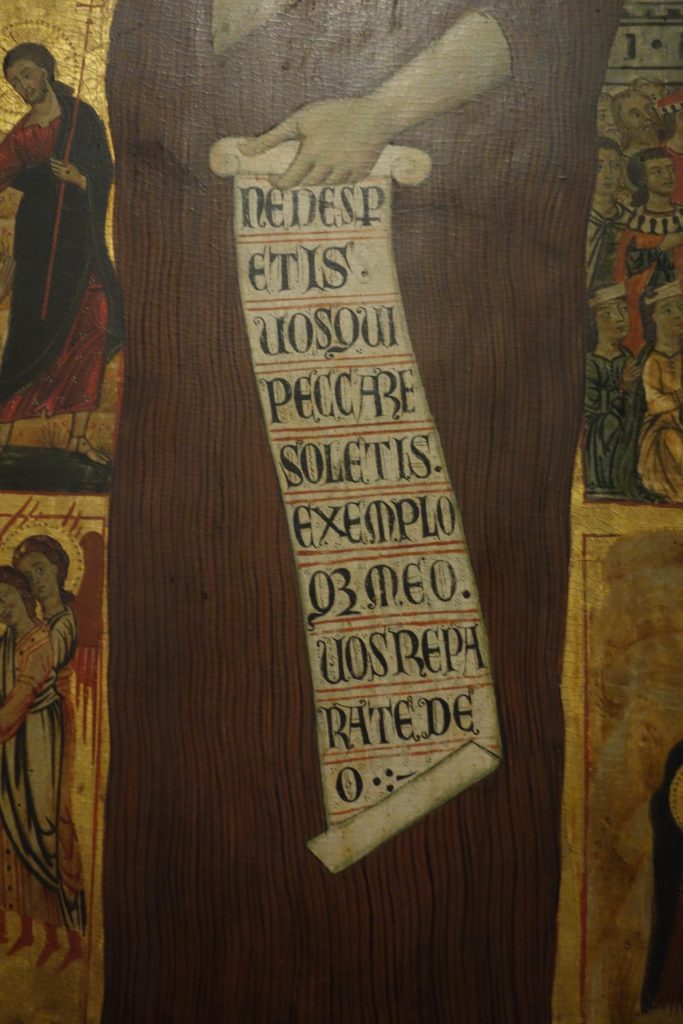 Alt Text: Detail of the iconic image of Mary Magdalen on the Accademia Vita Panel showing her scroll reading: NE DESPERETIS VOS QUI PECCARE SOLETIS EXEMPLOQUE MEO VOS REPARATE DEO or “do not despair those of you who are accustomed to sin, and in keeping with my example, return yourselves to God.”