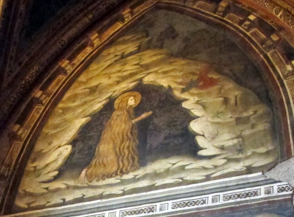 The fresco in the lunette on the right wall of the Brancaccio chapel with the Magdalen facing right, kneeling in the mouth of her cave receiving Communion from an angel who is flying in from the left.