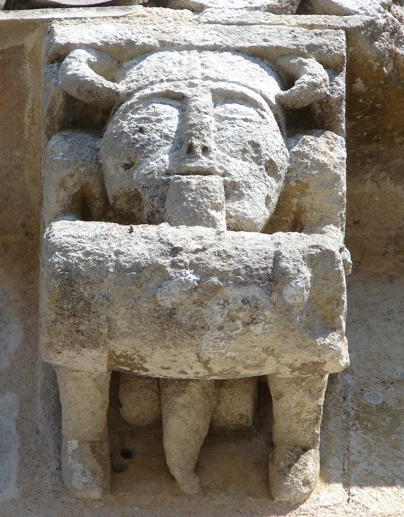 Barrel toting corbel figure with what looks like a penis dangling beneath his barrel. It is actually the end of his long beard.