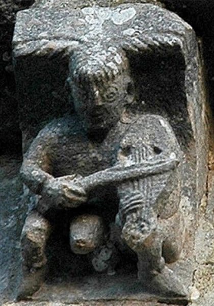 A viol player bows his instrument while an enormous penis protrudes from his robe.