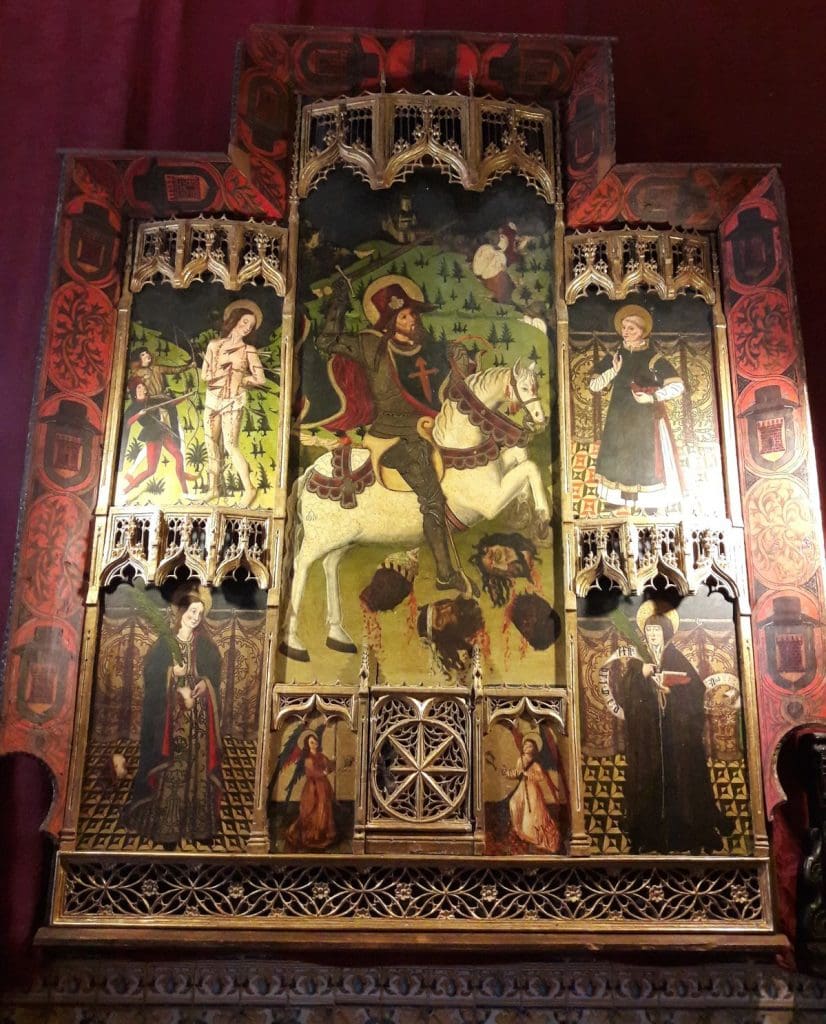 Eight paneled altarpiece depicting painted saints and carved gothic frames. 