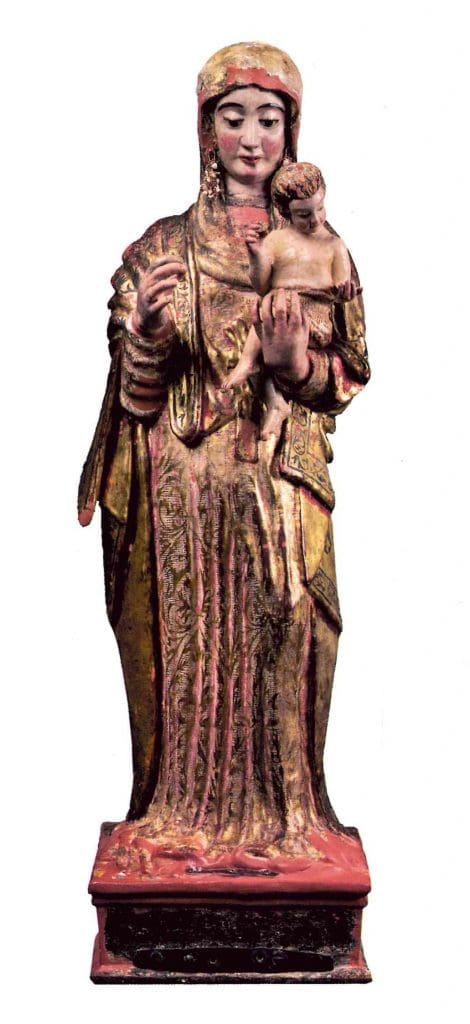 A painted wooden sculpture by an indigenous artist from sixteenth century colonial Peru representing a woman wearing elaborate robes, the Madonna of Copacabana, carrying a baby, the Christ child, in her right arm.